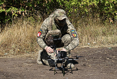 In this photo provided by Ukraine's 65th Mechanized Brigade press service, a Ukrainian soldier prepares an FPV drone to fire towards Russian positions in Zaporizhzhia region, Ukraine, Saturday, Sept. 19, 2026. 