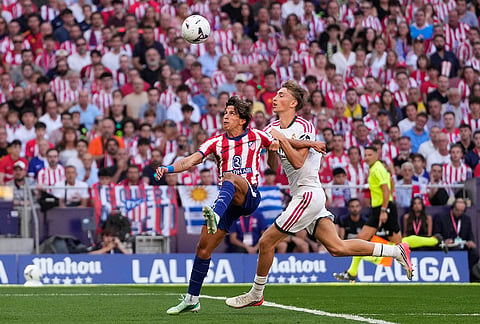Real Madrid's Dean Huijsen, right, fouls Atletico Madrid's Giuliano Simeone to give away a penalty shot and see a red card during a Spanish La Liga soccer match between Atletico Madrid and Real Madrid in Madrid, Sunday, Sept. 20, 2026. 