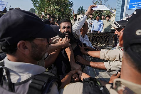 A supporter of the Jammu Kashmir Apni Party shouts slogans against the ruling government as police officers try to stop him during a protest demanding jobs, opposing a power tariff hike and pressing other demands in Srinagar, Indian-controlled Kashmir.