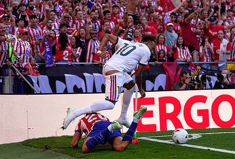 Atletico Madrid fans react as Atletico Madrid's Giuliano Simeone falls to the ground in a clash with Real Madrid's Kylian Mbappe during a Spanish La Liga soccer match between Atletico Madrid and Real Madrid in Madrid, Sunday, Sept. 20, 2026. 