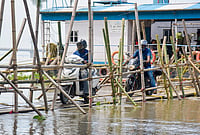 Day In Pics: September 21, 2026 | Photo: PTI : Commuters ride two-wheelers across a makeshift bamboo bridge to reach a ferry terminal over the Brahmaputra River, in Guwahati.