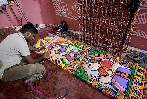 A worker paints an installation, themed on Rajasthan’s traditional festival 'Gangaur' for a ‘pandal’ ahead of the ‘Durga Puja’ festival, in Kolkata, Tuesday, Sept. 22, 2026. 