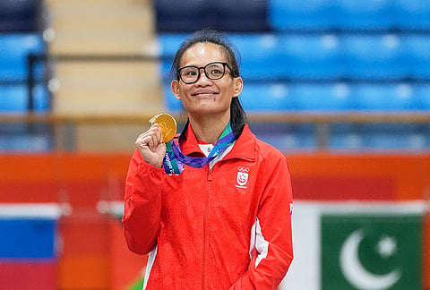 Gold medalist Teo Hui Hoon of Singapore poses on the podium during the medal ceremony for the women's traditional 60 kg mixed martial arts at the Asian Games in Nagoya, Japan, Tuesday, Sept. 22, 2026.  