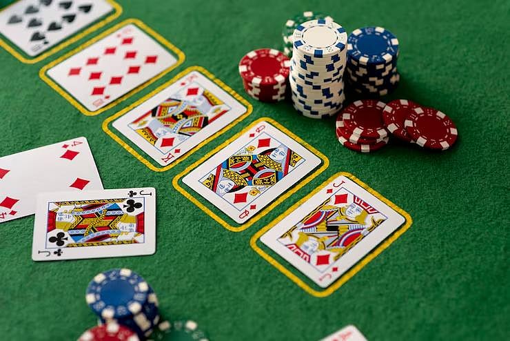 Poker cards and chips laid out on a green felt table