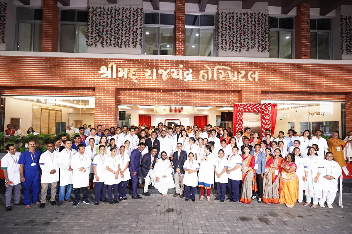 Medical staff and doctors posing together outside the Shrimad Rajchandra Hospital building