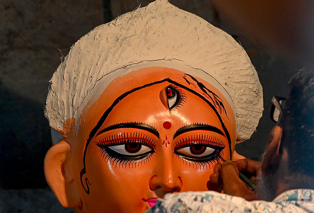 An artist paints on an idol of Goddess Durga ahead of the 'Durga Puja' festival, in Kolkata, Monday, Sept. 21, 2026.  - | Photo: PTI