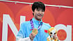 Hiro Komae/AP Photo : Gold medalist Yu Zidi of China poses on the podium after the women's 200-meter individual medley final in swimming at the Asian Games in Tokyo.