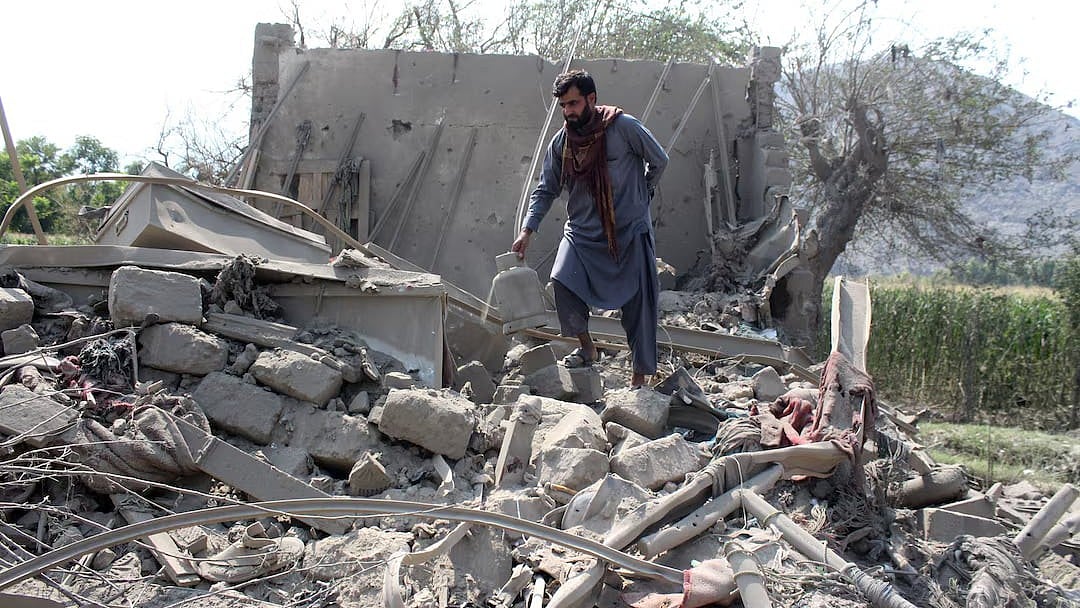 A man retrieves belongings from the debris of a house that was damaged in what the Taliban said was a Pakistani airstrike in Kunar province - Reuters