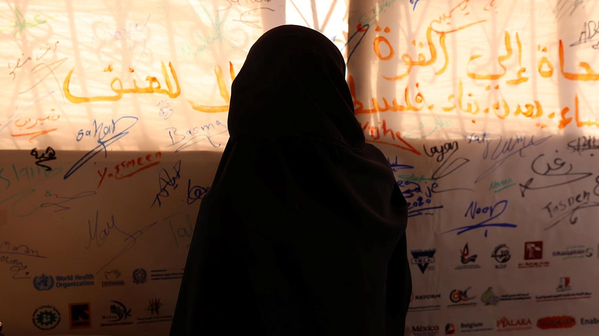 Inside the Haydar Abdel Shafi Centre in Gaza, a woman reflects before a wall of collective voices calling for dignity and an end to violence -  | Photo: UNFPA Palestine/Yasmeen Sous