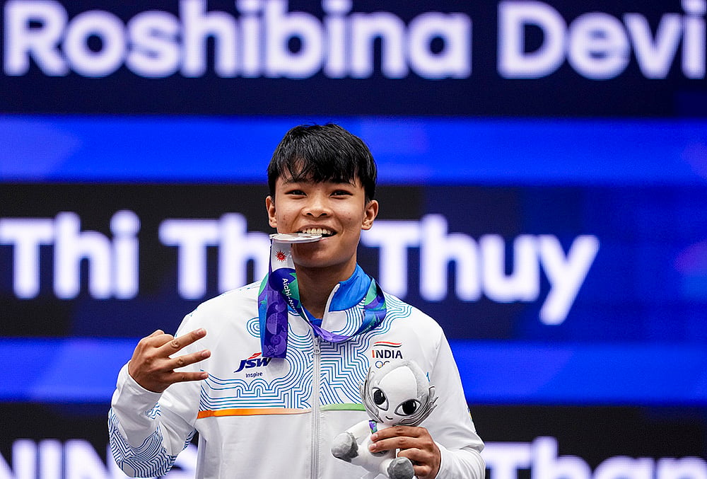 India’s Roshibina Devi Naorem holds the silver medal after the Women’s 60kg Wushu final match during the 20th Asian Games, in Nagoya, Japan, Thursday, Sept. 24, 2026. She lost to China's Zhang Xiaoyu, 0-2.  - | Photo: PTI/Arun Sharma