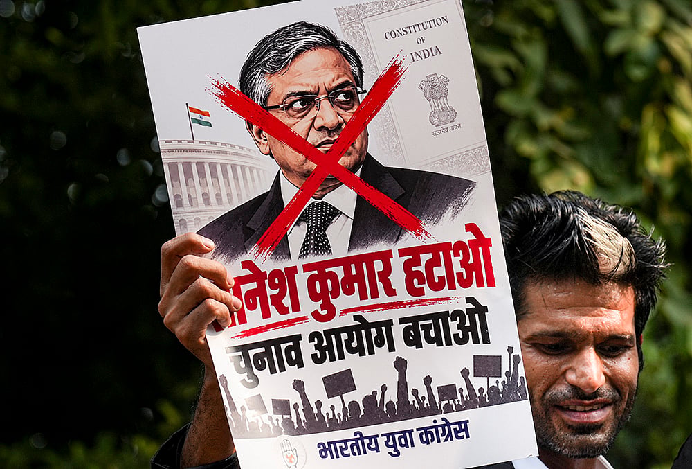 A protestor holds a poster of Chief Election Commissioner (CEC) Gyanesh Kumar during a protest by Indian Youth Congress (IYC) members against the CEC, in New Delhi, Wednesday, Sept. 23, 2026.  - | Photo: PTI/Karma Bhutia