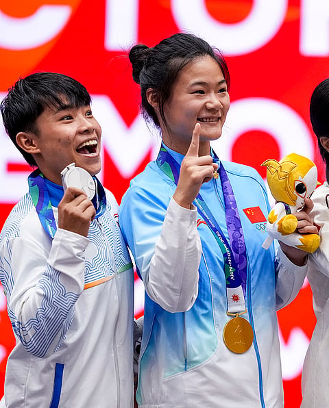 India’s silver medallist Roshibina Devi Naorem, left, and China's gold medallist Zhang Xiaoyu during the medal ceremony after the Women’s 60kg Wushu final match during the 20th Asian Games, in Nagoya, Japan, Thursday, Sept. 24, 2026. 