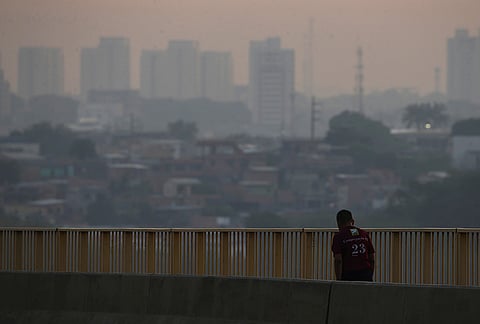 A man walks on a bridge as smoke from wildfires fills the air in Manaus, Amazonas state, Brazil, Wednesday, Sept. 23, 2026. 