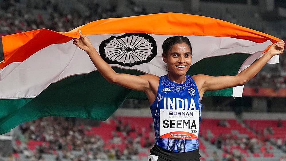 India’s Seema holds the national flag as she celebrates after winning the bronze medal in the women's 10,000m final during the Asian Games 2026, in Nagoya, Japan, Thursday, Sept. 24, 2026.  - | Photo: PTIArun Sharma