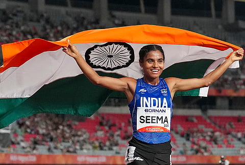 India’s Seema holds the national flag as she celebrates after winning the bronze medal in the women's 10,000m final during the Asian Games 2026, in Nagoya, Japan, Thursday, Sept. 24, 2026. 