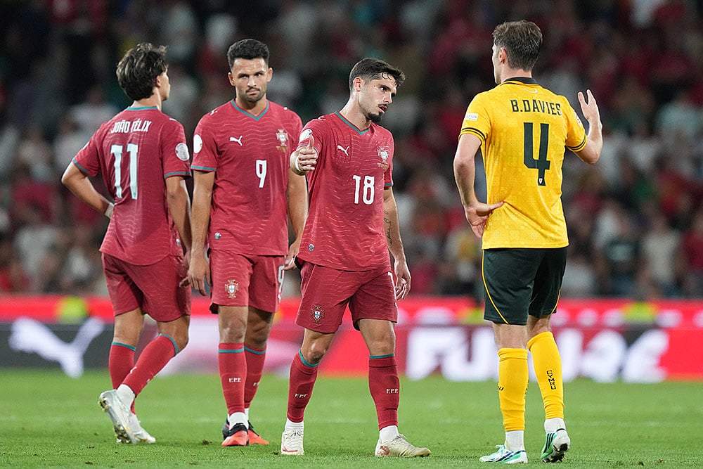 Wales' Ben Davies, right goes to shake hands with Portugal's Pedro Neto after the end of the Nations League soccer match between Portugal and Wales in Lisbon. - | Photo: AP/Armando Franca