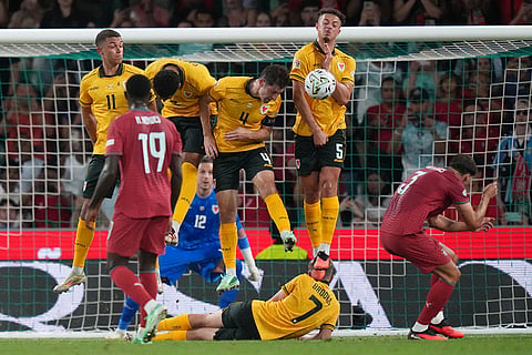 Wales' Ben Davies, third right block a direct free kick from Portugal's Cristiano Ronaldo during the Nations League soccer match between Portugal and Wales in Lisbon.