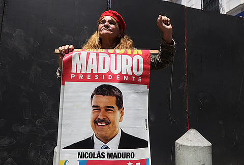 A woman holds a poster with an image of former President Nicolas Maduro during a government-organized rally in support of acting President Delcy Rodriguez's participation at the U.N. in Caracas, Venezuela.