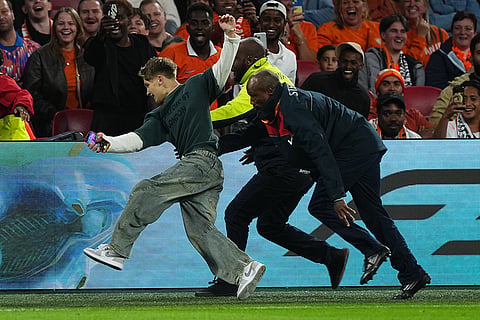Security chases a fan who invaded the pitch during the UEFA Nations League soccer match between the Netherlands and Germany in Amsterdam, Netherlands.