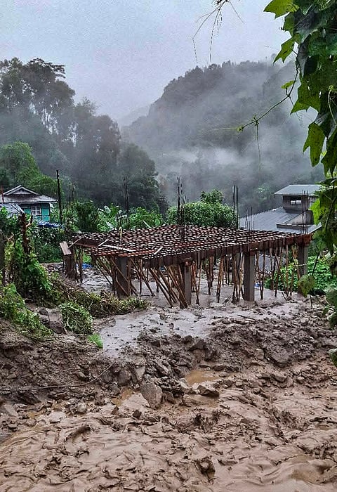 Mud and debris cover the area following a landslide triggered by continuous rainfall on late Thursday, at Rimbi village, in Yuksom-Tashiding, Sikkim.