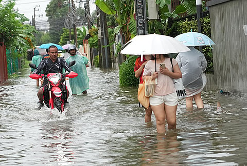 People wade through floodwaters after heavy rain in Bangkok, Thailand Saturday, Sept. 26, 2026. 