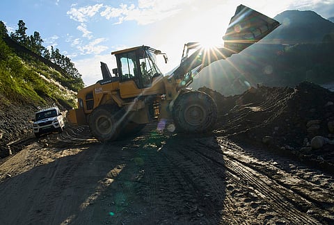 An excavator cuts into a hillside to build a temporary road connecting towns and villages after flash floods destroyed the existing road in Nepal's Nuwakot district, Tuesday, Sept. 22, 2026. 