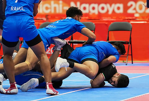 Iran's Amirhossein Taghipour gets tackled by the Indian players during the men's kabaddi final at the Asian Games in Tokai City, Japan, Saturday, Sept. 26, 2026.
