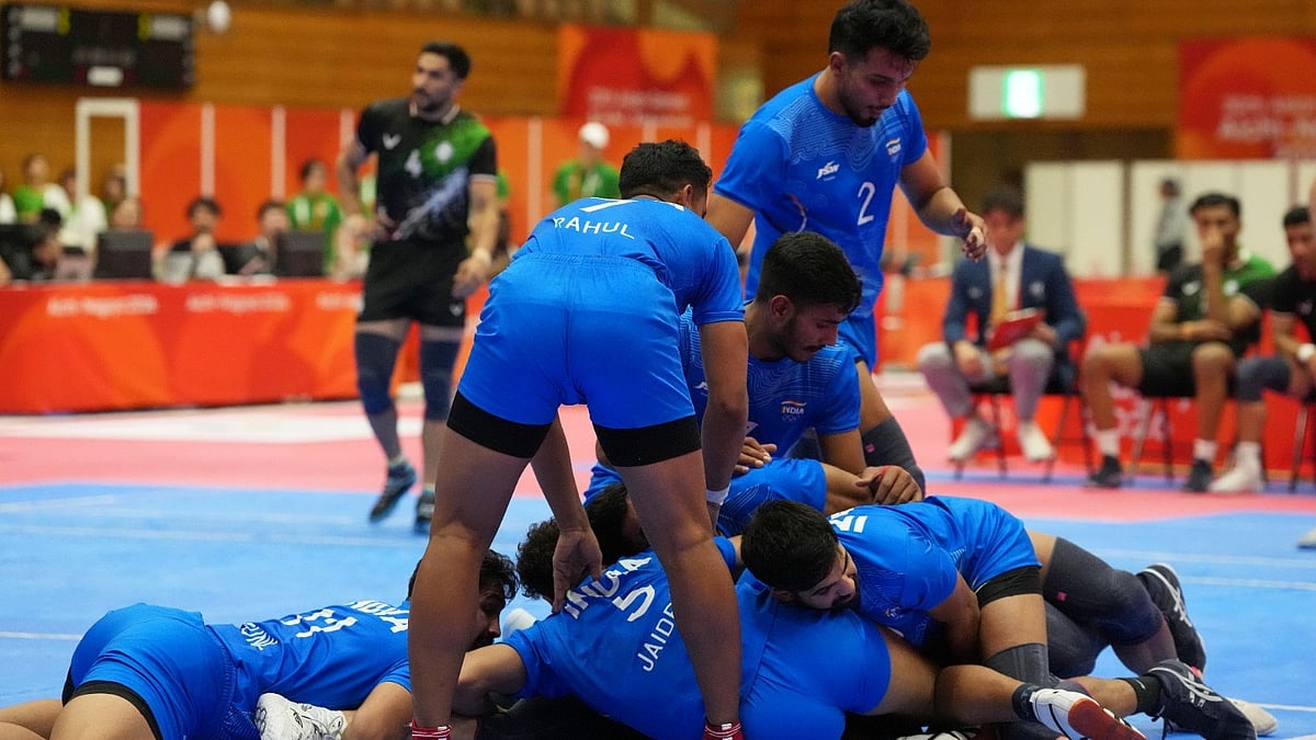 Indian players tackle an Iranian player during the men's kabaddi final at the Asian Games in Tokai City, Japan. - AP Photo/Mark Baker