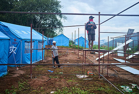 Workers weld metal frames while building temporary shelters for survivors of recent flash floods in Nepal's Nuwakot district, Wednesday, Sept. 23, 2026.
