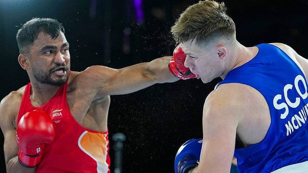 India's Kapil Pokhariya, in red, competes against Scotland's Robert McNulty during the men's 90kg boxing match at the 23rd Commonwealth Games, in Glasgow, Scotland. - | Photo: PTI/Ravi Choudhary