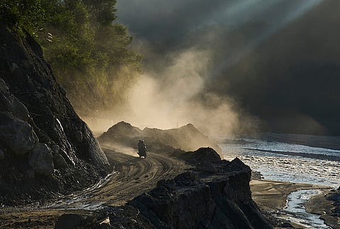A motorcyclist travels along a newly built temporary road cut into a hillside to reconnect villages after flash floods destroyed the existing road in Nepal's Nuwakot district, Tuesday, Sept. 22, 2026. 