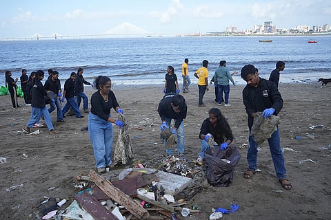Students clean a beach following the immersion of lord Ganesh idols during the Ganesh Chaturthi festival, in Mumbai.