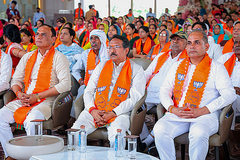 BJP Delhi President Harsh Malhotra, centre, and others listen to Prime Minister Narendra Modi's monthly 'Mann ki Baat' radio programme, in New Delhi.