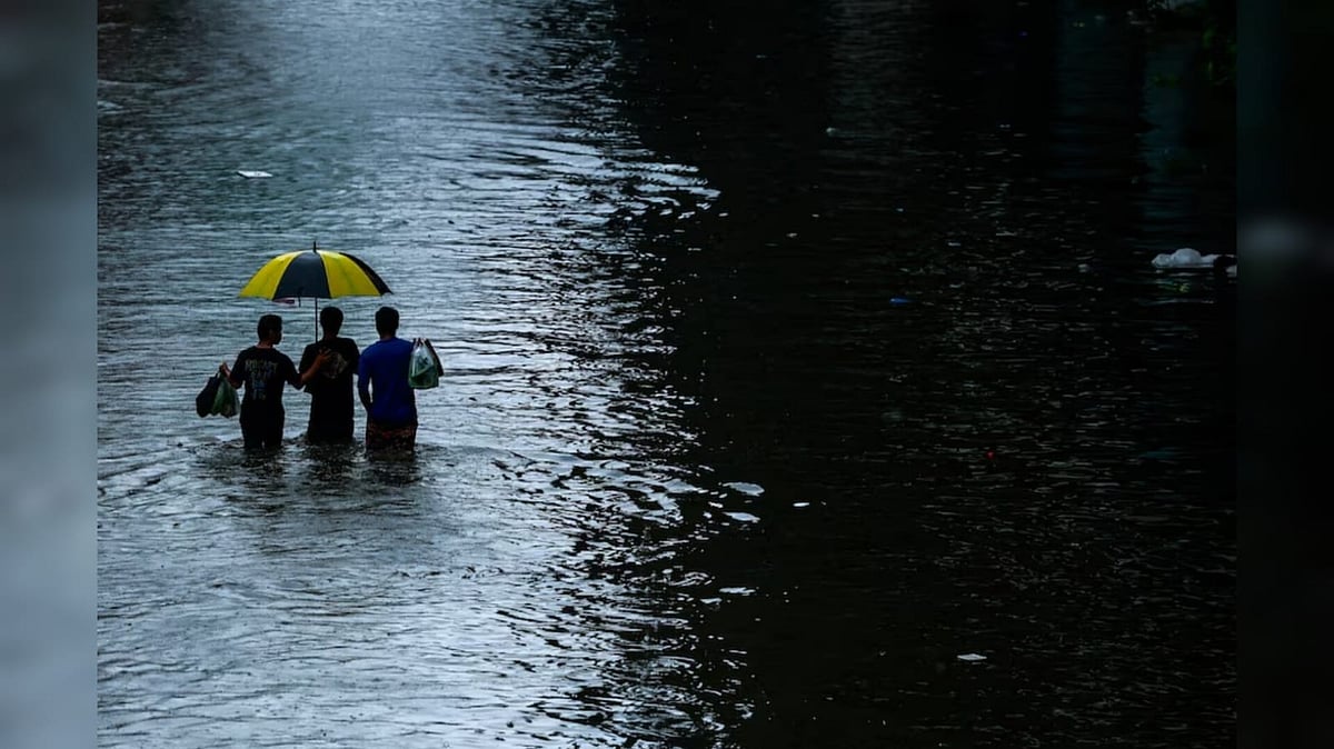  People wade through a flooded street during heavy rain in Bangkok - Reuters