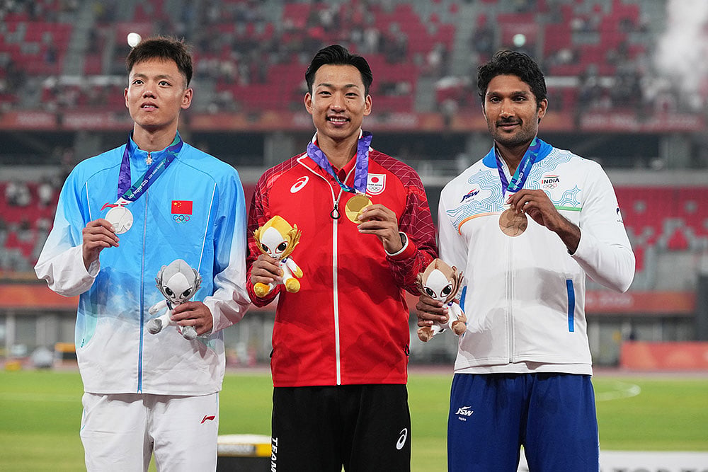 Gold medalist Japan's Yuma Maruyama, center, flanked by silver medalist China's Chen Xinghua left, and bronze medalist India's Tejaswin Shankar, right, pose on the podium during the medal ceremony in the decathlon 1500m at the Asian Games in Nagoya, Japan, Sunday, Sept. 27, 2026. - | Photo: AP/Mark Baker