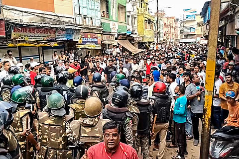 Security personnel interact with people following stone-pelting incidents during protests against the proposed removal of a portion of the 'Shahi Masjid' for road widening, in Ujjain, Madhya Pradesh, Monday, Sept. 28, 2026.