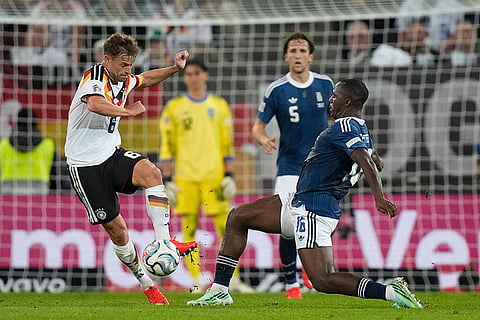 Germany's Joshua Kimmich takesthe ball in front of Greece's Andreas Tetteh during the UEFA Nations League soccer match between Germany and Greece in Augsburg, Germany, Sunday, Sept. 27, 2026.
