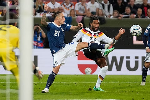 Greece's Kostas Tsimikas, left, and Germany's Serge Gnabry fight for the ball during the UEFA Nations League soccer match between Germany and Greece in Augsburg, Germany, Sunday, Sept. 27, 2026.