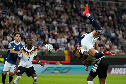 Greece's Ntinos Mavropanos falls over Germany's Jonathan Tah during the UEFA Nations League soccer match between Germany and Greece in Augsburg, Germany, Sunday, Sept. 27, 2026.