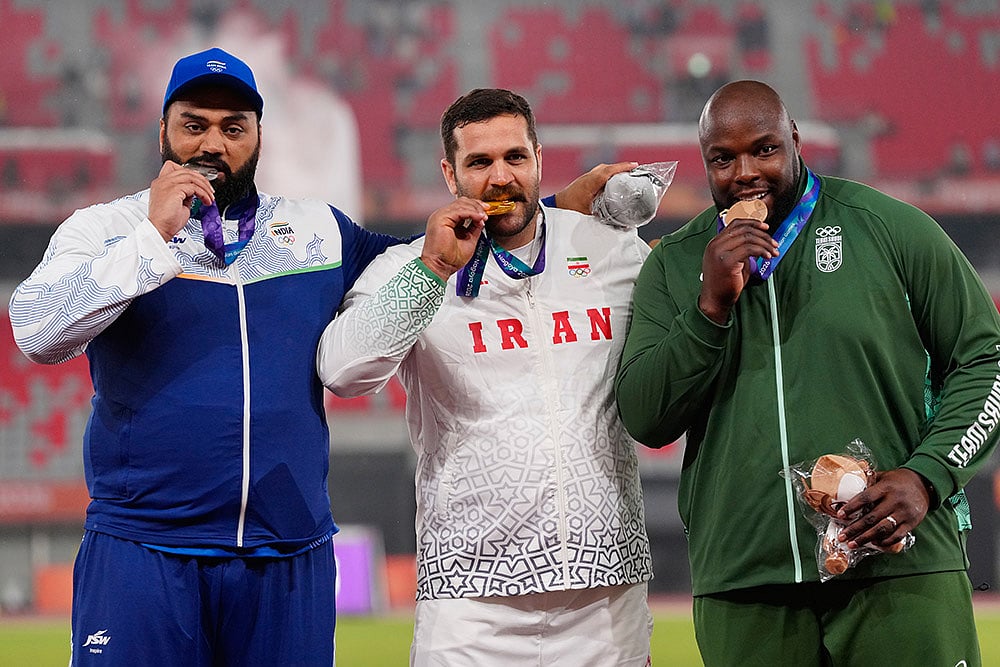 Gold medalist Iran's Mohammadreza Tayebise, center, flanked by silver medalist, India's Tajinderpal Singh Toor, left, and bronze medalist Saudi Arabia's Mohammed Tolu, poses on the podium during the medal ceremony for the men's shot put final at the Asian Games in Nagoya, Japan, Saturday, Sept. 26, 2026. - | Photo: AP/Eugene Hoshiko