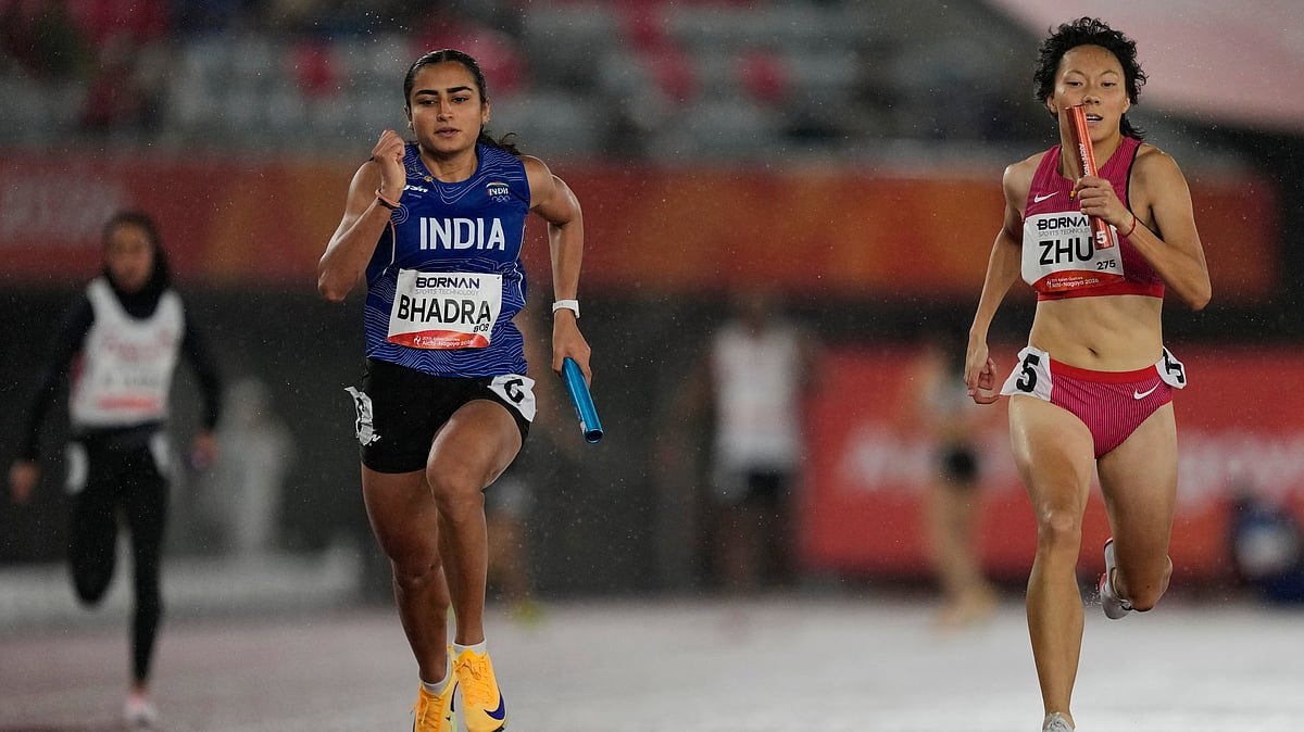 India's Harita Bhadra, left, and China's Zhu Junying race to the finish line during their heat of the 4 x 100m mixed relay at the Asian Games in Nagoya, Japan, Monday, Sept. 28, 2026 - (AP Photo/Dita Alangkara)
