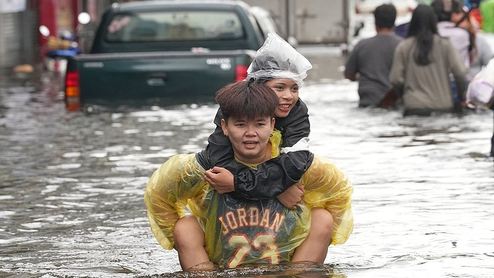 People wade through a flooded street after a heavy rain in Bangkok, Thailand, Monday, Sept. 28, 2026.  - | Photo: AP/Sakchai Lalit