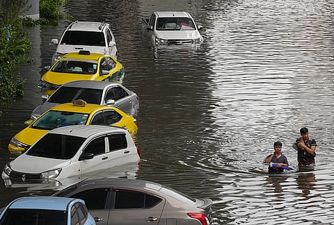 People wade through a flooded street after heavy rain in Bangkok, Thailand, Sunday, Sept. 27, 2026. 