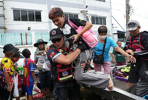 Rescuers evacuate people from a flooded area to a safer place in Bangkok, Thailand, Monday, Sept. 28, 2026. 