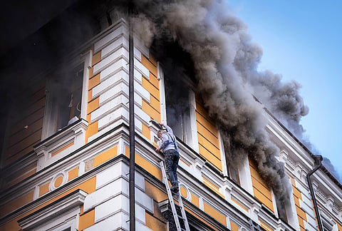 A man evacuates a burning building using a rescue ladder from the National Academy of Sciences building damaged after a Russian drone strike in the center of Kyiv, Ukraine, Monday, Sept. 28, 2026. 
