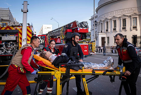 Paramedics evacuate an injured woman into an ambulance in front of the National Academy of Sciences building damaged after a Russian drone strike in the center of Kyiv, Ukraine, Monday, Sept. 28, 2026. 
