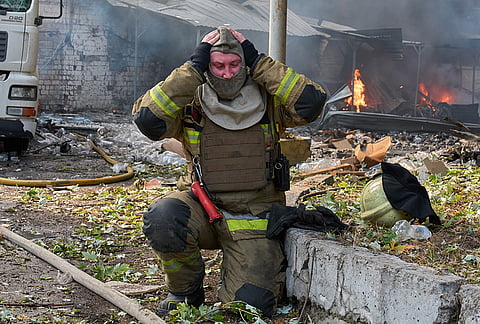 A firefighter gets ready to put out a fire following Russia's air attack on Kyiv, Ukraine, Monday, Sept. 28, 2026. 
