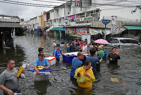 People wade through the flooded streets after heavy rain in Bangkok, Thailand, Monday, Sept. 28, 2026. 