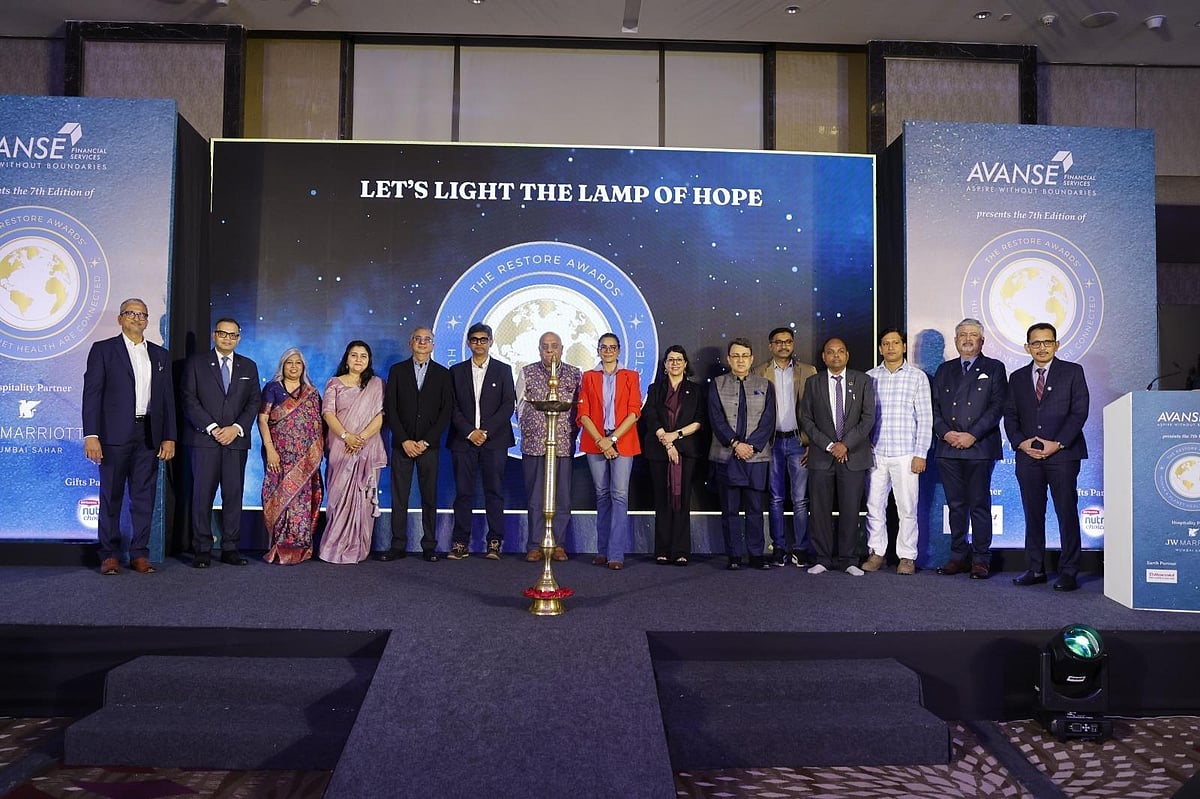 Group of people standing on stage at an event with Lets Light The Lamp Of Hope background.