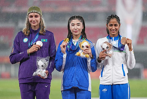 Gold medalist, Barnokhon Sayfullaeva of Uzbekistan, centre, silver medalist, Kristina Ovchinnikova of Kazakhstan, left, and bronze medalist Pooja of India pose on the podium following the women's high jump final at the Asian Games in Nagoya, Japan, Tuesday, Sept. 29, 2026. 